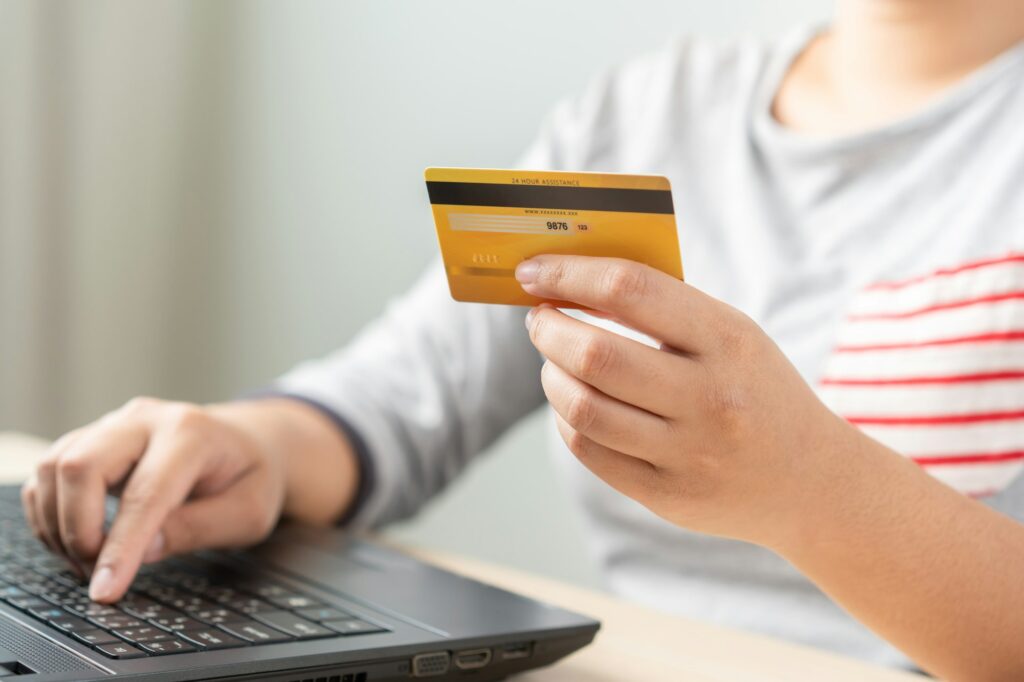 Woman using laptop for online shopping by credit card. Cashless payment using laptop.