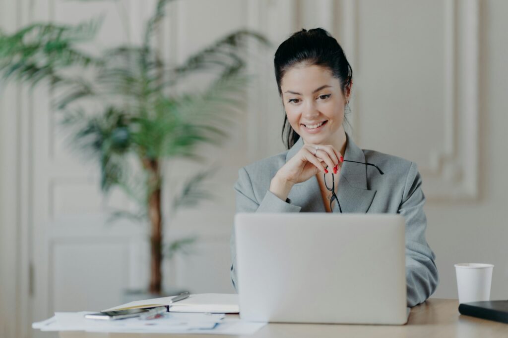 Woman searches update notification for laptop computer, takes off glasses